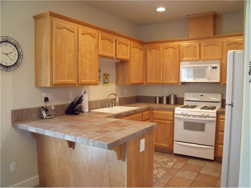 Kitcehn features tile counters, alder cabinets