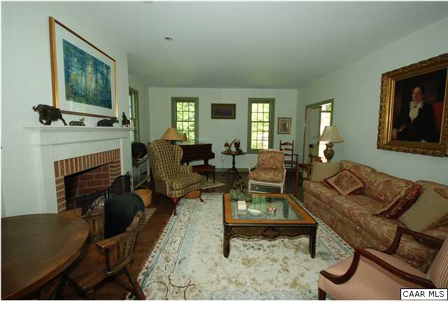 Living room w/ hardwood floors and wood burning fireplace