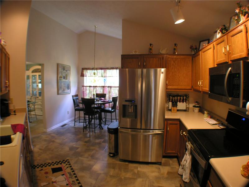 Vinyl floor, eat-in with wood cabinets and high ceilings