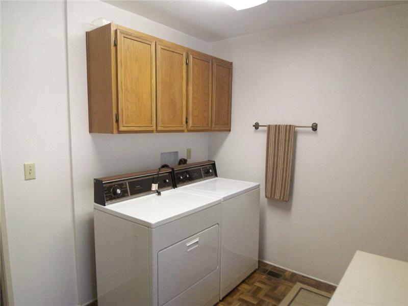 Interior laundry room with built-ins and storage closet, accessible from the patio
