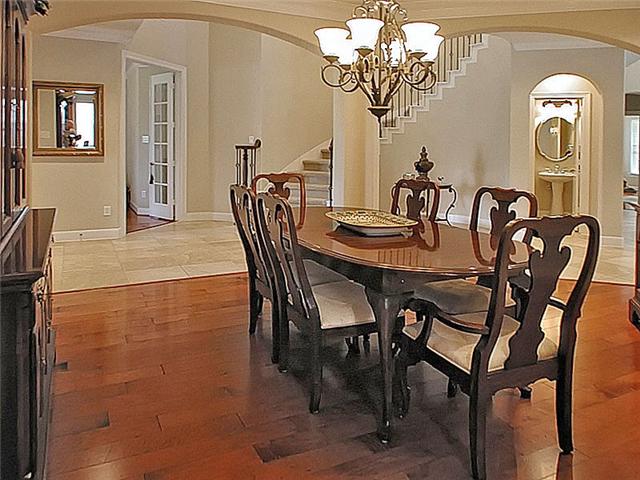 Formal dining, wood floors & arches.