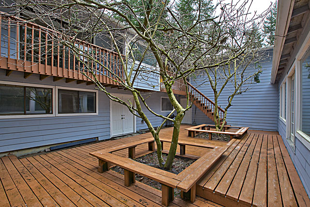 Large deck for entertaining to the right is the indoor pool to the left is the house.