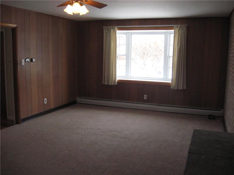 Family room with Bow window, wood burning fireplace, new carpeting and ceiling fan.