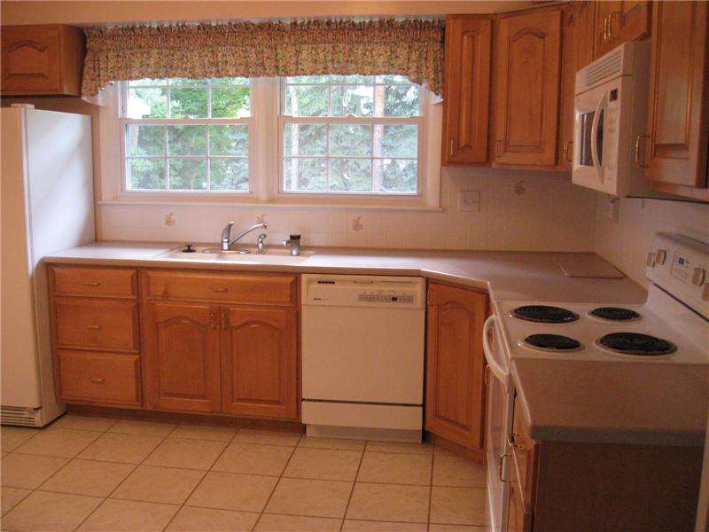 Beautifully updated kitchen with Corian counter tops, ceramic tile flooring, eat-in kitchen.