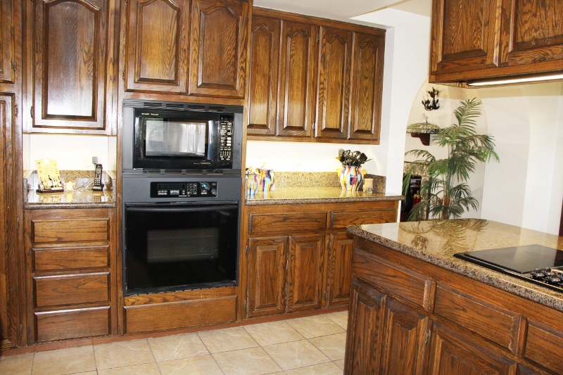Kitchen with granite counter tops, built in microwave, and tile floors