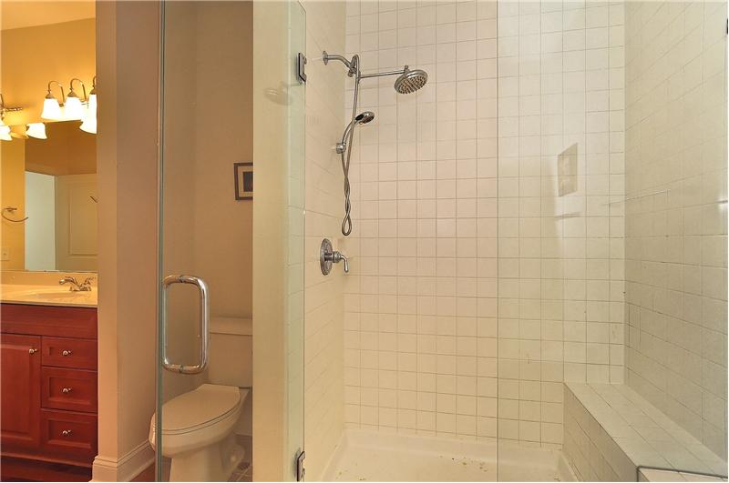 Glass enclosed walk-in shower with bench sit