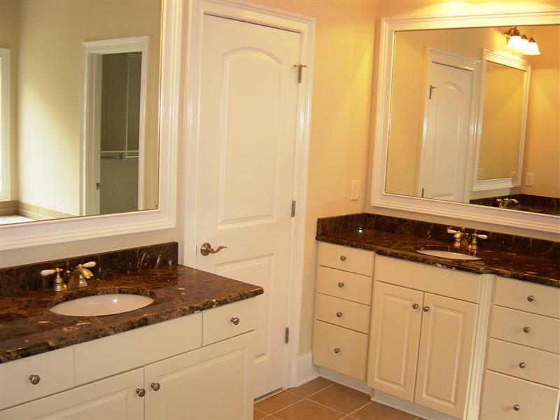 Luxurious master bath has dual, separate vanities, granite counter tops and raised cabinetry