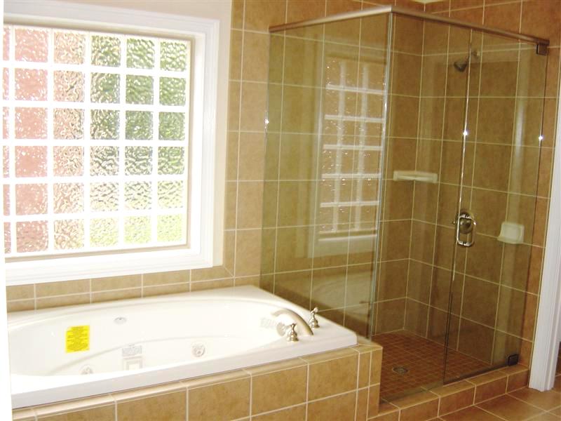 There is a frameless, glass enclosed walk-in shower and a relaxing jetted whirlpool tub