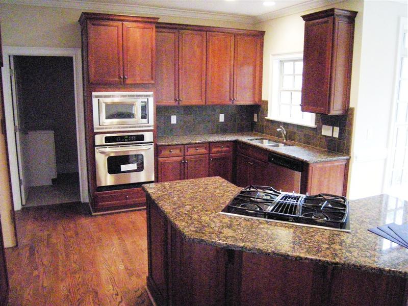Gourmet kitchen has granite counter tops, gas cooktop, all stainless steel appliances and tile backsplash