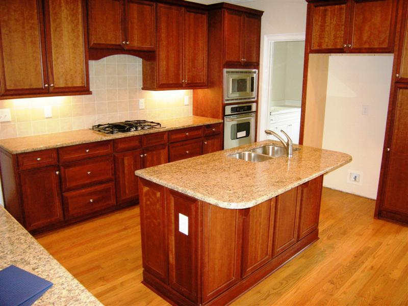 Gourmet kitchen features a large island with sink, granite counter tops and 42inch custom cabinets