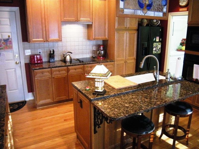Gourmet kitchen has granite counter tops, built-in sink on island/bar, 42inch cabinets, gas cooktop, tile backsplash and pantry