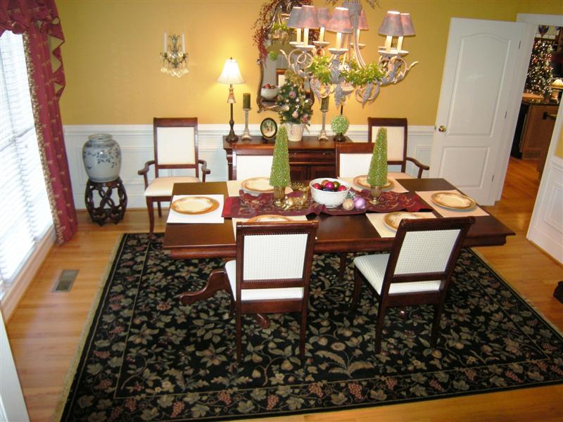 Dining room features custom paint and millwork, wood floors and upgraded lighting