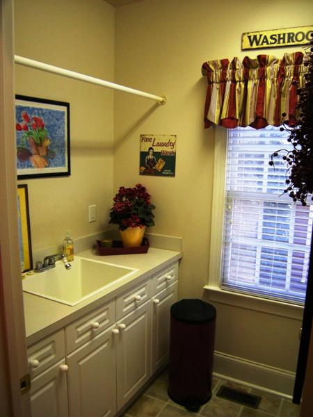 Laundry room on the main level has cabinetry and sink
