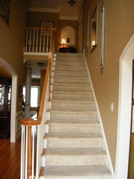 Carpeted stairway to upper level