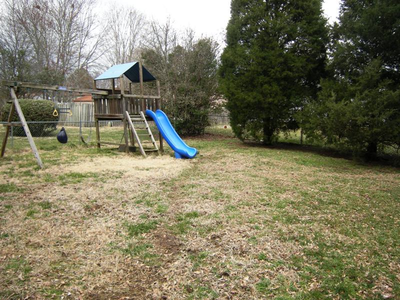 Backyard is level and fenced with an included play-gym for the kids