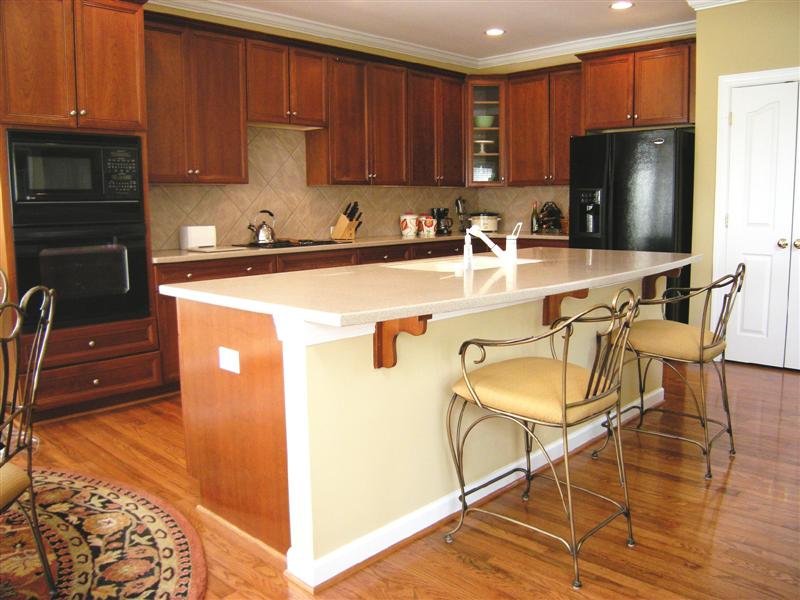 Gourmet kitchen has black, GE Professional appliances including a convection oven and spacious hard surface counters