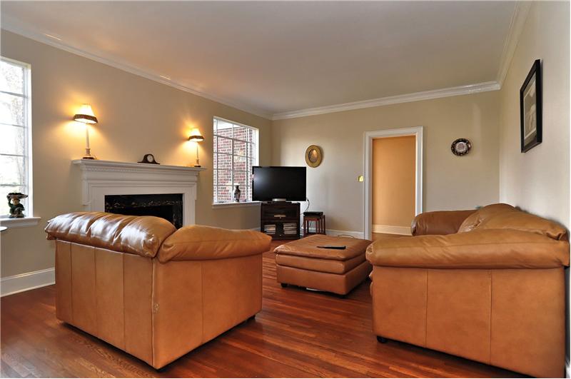 The spacious living room has gorgeous hardwoods & a wood burning fireplace