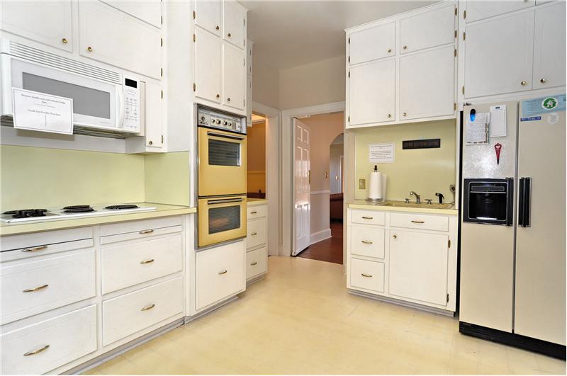 The pristine kitchen has double ovens, electric cooktop, two sinks and included refrigerator