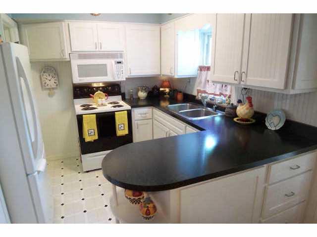 Remodeled kitchen with new cabinets, countertops, floor and refrigerator