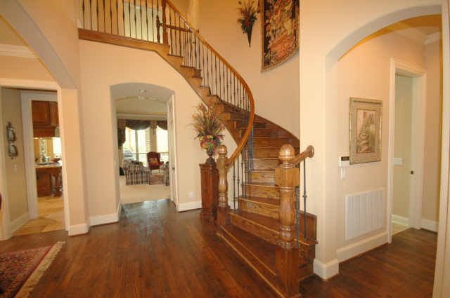 Entry includes wrought iron spindles and handscraped hardwoods.