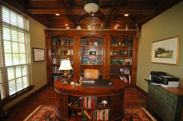 Beautiful study with a wall of maple built-in bookcases, a wood beam ceiling and handscraped hardwood floors.