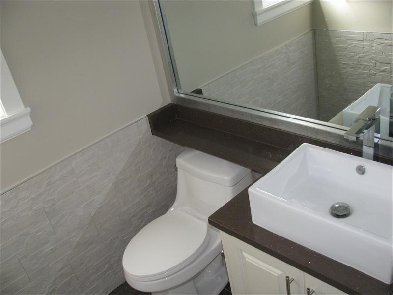 Powder room with quartz counter and tile floor