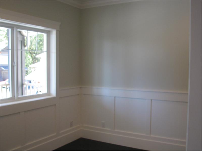 Den off the front entrance with wainscoting