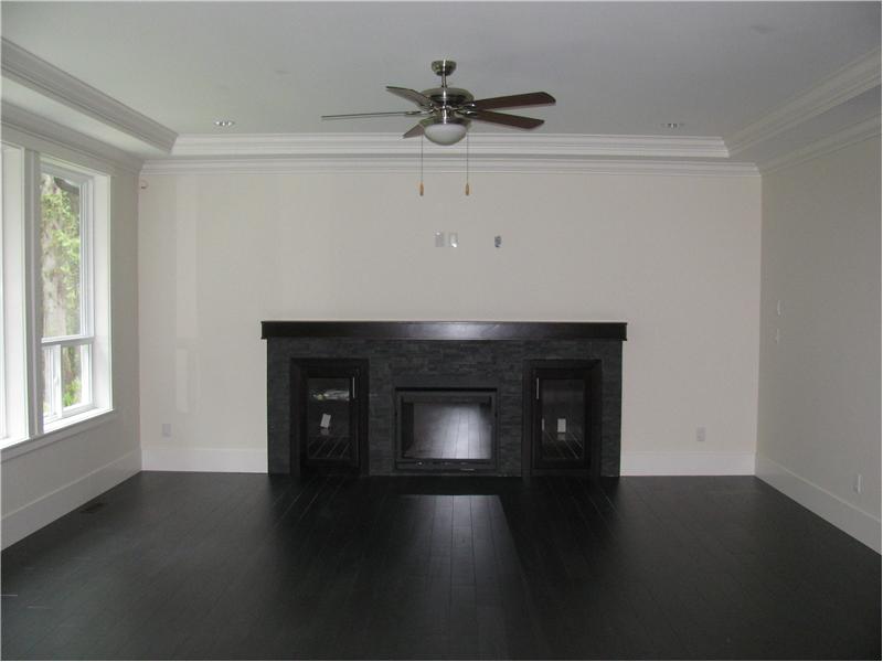 Family room with room for a flat screen TV, laminate floor, crown moulding and baseboard